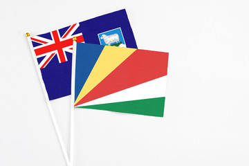 Seychelles and Falkland Islands stick flags on white background. High quality fabric, miniature national flag. Peaceful global concept.White floor for copy space.