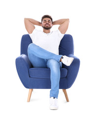 Fototapeta na wymiar Young man resting in armchair isolated on white