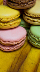 Colored macarons isolated on wooden dish, typical French dish