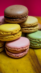 Colored macarons isolated on wooden dish, typical French dish