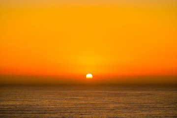 Beautiful and peaceful golden sunset or sunrise over the ocean.