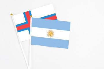 Argentina and Faroe Islands stick flags on white background. High quality fabric, miniature national flag. Peaceful global concept.White floor for copy space.