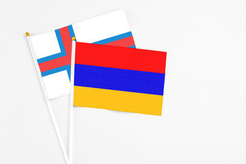 Armenia and Faroe Islands stick flags on white background. High quality fabric, miniature national flag. Peaceful global concept.White floor for copy space.