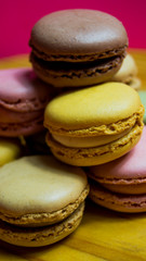 Colored macarons isolated on wooden dish, typical French dish
