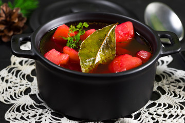 Red borscht soup in bowl.