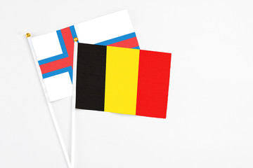 Belgium and Faroe Islands stick flags on white background. High quality fabric, miniature national flag. Peaceful global concept.White floor for copy space.