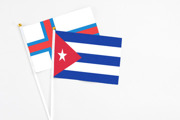 Cuba and Faroe Islands stick flags on white background. High quality fabric, miniature national flag. Peaceful global concept.White floor for copy space.