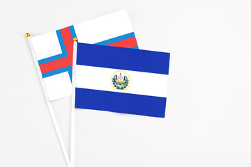 El Salvador and Faroe Islands stick flags on white background. High quality fabric, miniature national flag. Peaceful global concept.White floor for copy space.