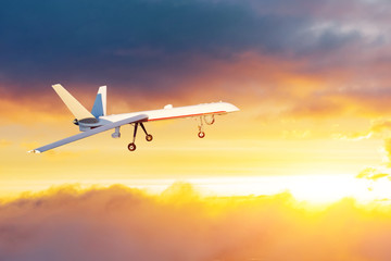Fototapeta na wymiar Unmanned air vehicle remote piloted aircraft drone performing in sunset cloudscape panorama.