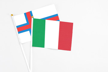 Italy and Faroe Islands stick flags on white background. High quality fabric, miniature national flag. Peaceful global concept.White floor for copy space.