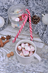 mug full of marshmallow on a milk chocolate on a table in christmas decoration