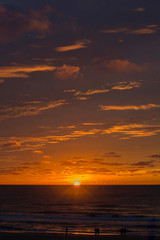 The sundown over the sea in Europe. Yellow and orange light with many clouds.