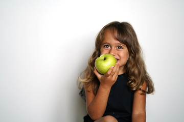 4 year old Italian girl eats a green apple