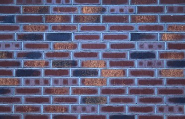 Decorative wall texture, background. Rusty and matted bricks. The fragment of a new decorative bricklaying. The design of multi-colored stylish exterior