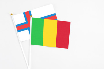 Mali and Faroe Islands stick flags on white background. High quality fabric, miniature national flag. Peaceful global concept.White floor for copy space.