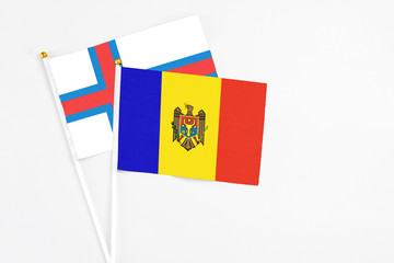 Moldova and Faroe Islands stick flags on white background. High quality fabric, miniature national flag. Peaceful global concept.White floor for copy space.