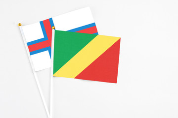 Republic Of The Congo and Faroe Islands stick flags on white background. High quality fabric, miniature national flag. Peaceful global concept.White floor for copy space.