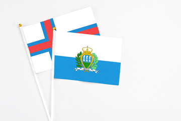 San Marino and Faroe Islands stick flags on white background. High quality fabric, miniature...