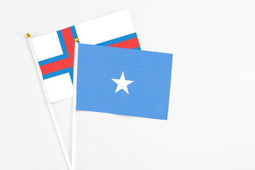 Somalia and Faroe Islands stick flags on white background. High quality fabric, miniature national flag. Peaceful global concept.White floor for copy space.