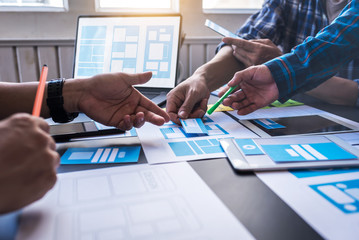Graphic mobile user experience design teamwork help to design new job in modern office. Design...