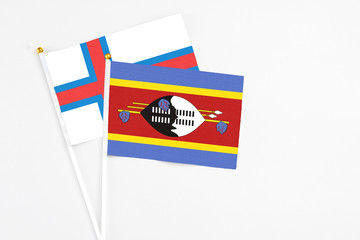 Swaziland and Faroe Islands stick flags on white background. High quality fabric, miniature national flag. Peaceful global concept.White floor for copy space.