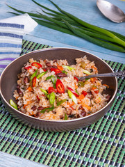 Traditional Jamaican and Mexican dish - rice with beans and vegetables in a bowl on a bamboo napkin, delicious vegetarian dish