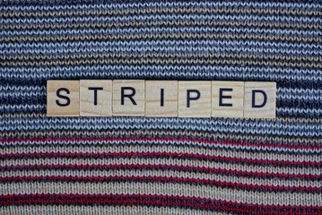 the word striped of wooden letters lies on colored matter