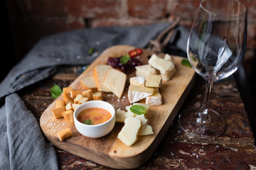 Cheese Plate Served with Onion Marmalade and Honey. Rustic Background