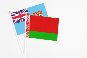 Belarus and Fiji stick flags on white background. High quality fabric, miniature national flag. Peaceful global concept.White floor for copy space.