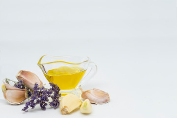 Allium sativum or garlic, jug with extra virgin olive oil and heather branch (Calluna vulgaris)