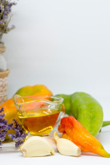 Allium sativum or garlic, green and red peppers, carrots and heather branch (Calluna vulgaris). Vegetable still life. Food for vegetarians or vegan diet