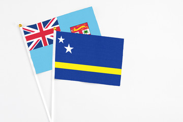 Curacao and Fiji stick flags on white background. High quality fabric, miniature national flag. Peaceful global concept.White floor for copy space.