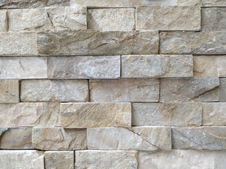 Modern uneven horizontal narrow bricks of stone rock tiles placed on each other as contemporary natural material indoors or outdoors decoration