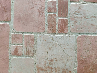 Pink, red and brown uneven stone blocks, bricks or tiles for indoor or outdoor floor or wall decoration made of rough material