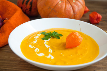 mashed pumpkin soup with cream and physalis
