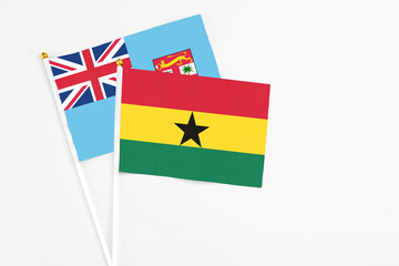 Ghana and Fiji stick flags on white background. High quality fabric, miniature national flag. Peaceful global concept.White floor for copy space.