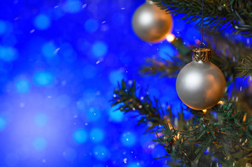 Christmas toys on the Christmas tree, on a blue bokeh background, with snow. New Year card