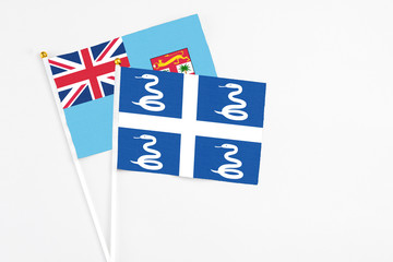 Martinique and Fiji stick flags on white background. High quality fabric, miniature national flag. Peaceful global concept.White floor for copy space.