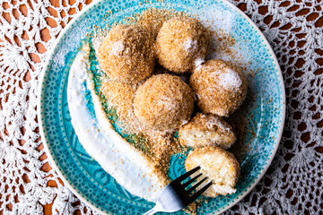 Cottage cheese dumplings with breadcrumbs and powdered sugar on a decorative plate