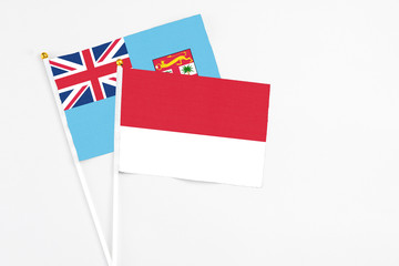 Monaco and Fiji stick flags on white background. High quality fabric, miniature national flag. Peaceful global concept.White floor for copy space.