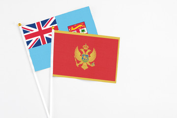 Montenegro and Fiji stick flags on white background. High quality fabric, miniature national flag. Peaceful global concept.White floor for copy space.