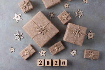 Christmas gifts in paper packaging on a gray background. Concept: packaging and decor from recyclable eco-natural materials.