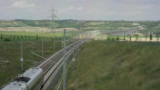 train sproaches tunnel on railways in the german countryside going through lush green hills