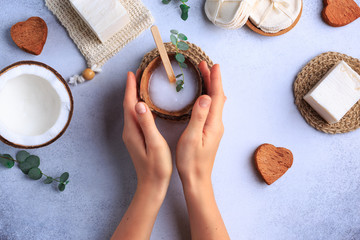 Natural cosmetic products setting with soaps and fresh herbs top view woman hands