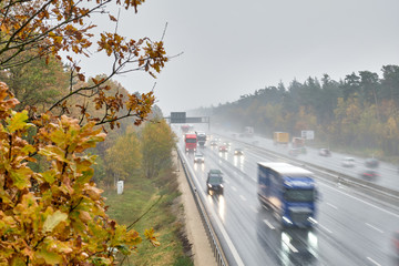 The highway A3 near Nuremberg with many cars with lights switched on driving with speed on a rainy...