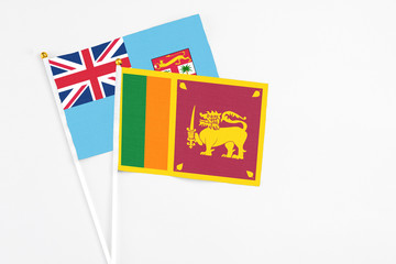 Sri Lanka and Fiji stick flags on white background. High quality fabric, miniature national flag. Peaceful global concept.White floor for copy space.