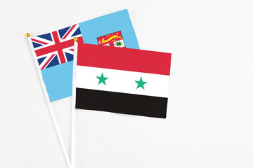 Syria and Fiji stick flags on white background. High quality fabric, miniature national flag. Peaceful global concept.White floor for copy space.