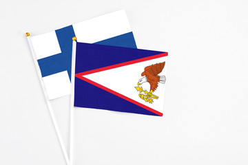 American Samoa and Finland stick flags on white background. High quality fabric, miniature national flag. Peaceful global concept.White floor for copy space.