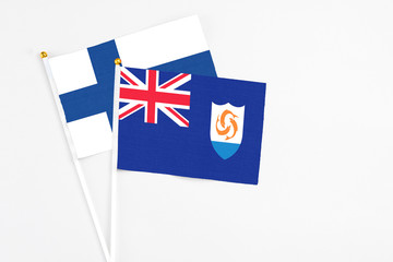 Anguilla and Finland stick flags on white background. High quality fabric, miniature national flag. Peaceful global concept.White floor for copy space.