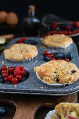 streusel muffins with blueberry, raspberry and red currant on rustic wooden table